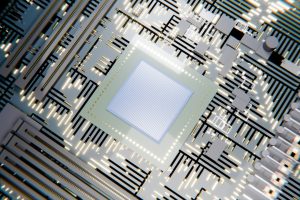 A glowing microchip on a circuit board with light patterns